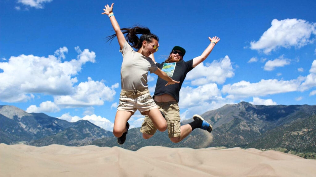 Editora de Travel Lemming, Abigail y su esposo posando en un tiro en suspensión en la cima de High Dune