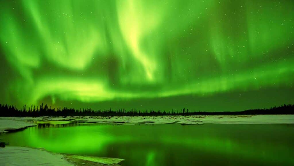 El reflejo de la brillante aurora boreal en un lago en Fairbanks
