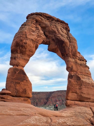 Editora de Travel Lemming, Abigail y su amiga posando debajo de Delicate Arch