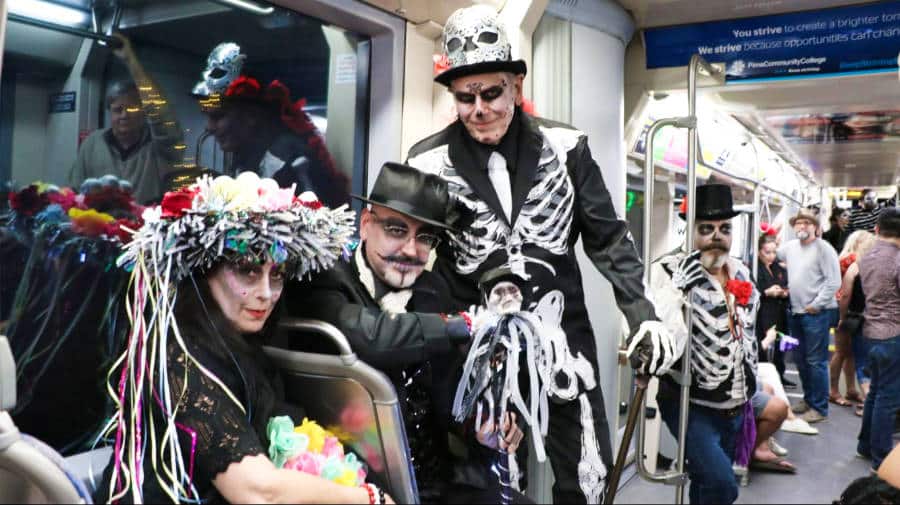 La autora Betty Hurd con un disfraz de esqueleto con los lugareños dentro del tranvía SunLink en Tucson