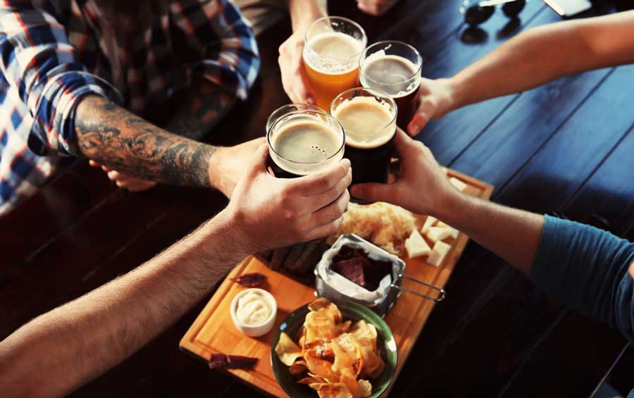 Un grupo de amigos brindando con sus vasos de cerveza