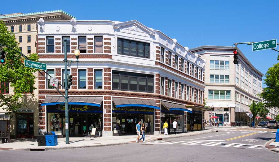 La gente que cruza la calle en la esquina de una calle en Asheville, Carolina del Norte