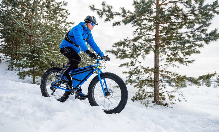 Un hombre montado en su bicicleta de neumáticos gordos durante el invierno en Breckenridge