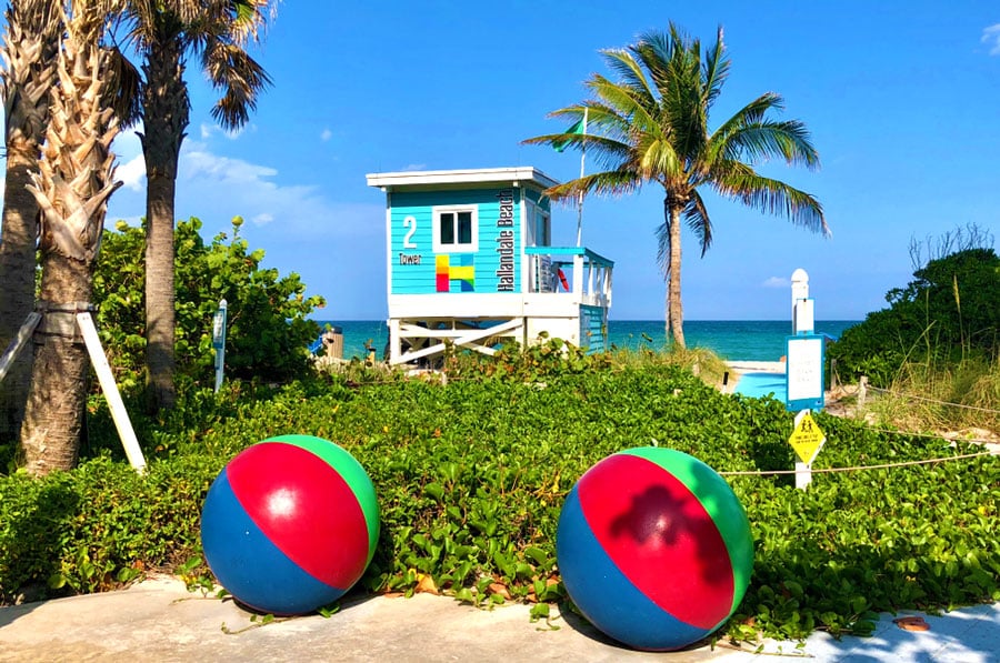 Vista de dos esculturas de pelotas de playa y una torre de salvavidas en Hallandale Beach