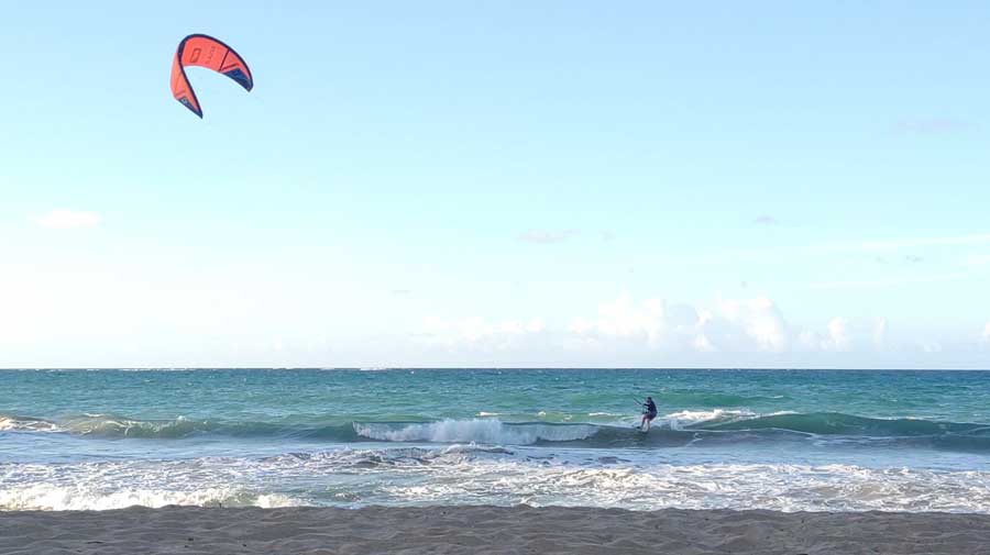 Un hombre disfrutando del kitesurf bajo el cielo azul claro en San Juan, Puerto Rico