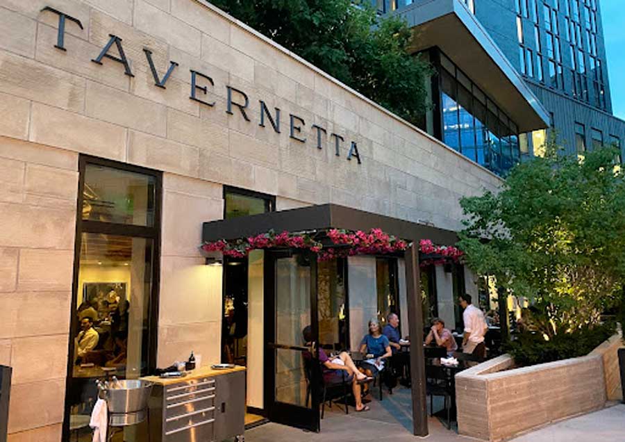 Gente disfrutando de su comida fuera de la Tavernetta