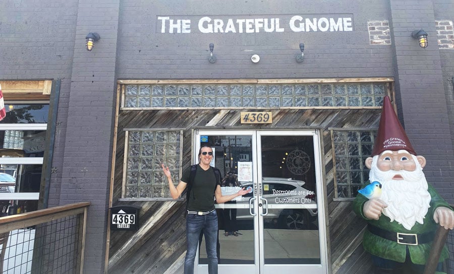 El fundador de Travel Lemming, Nate, posa para una foto en la entrada de The Grateful Gnome Sandwich Shoppe & Brewery